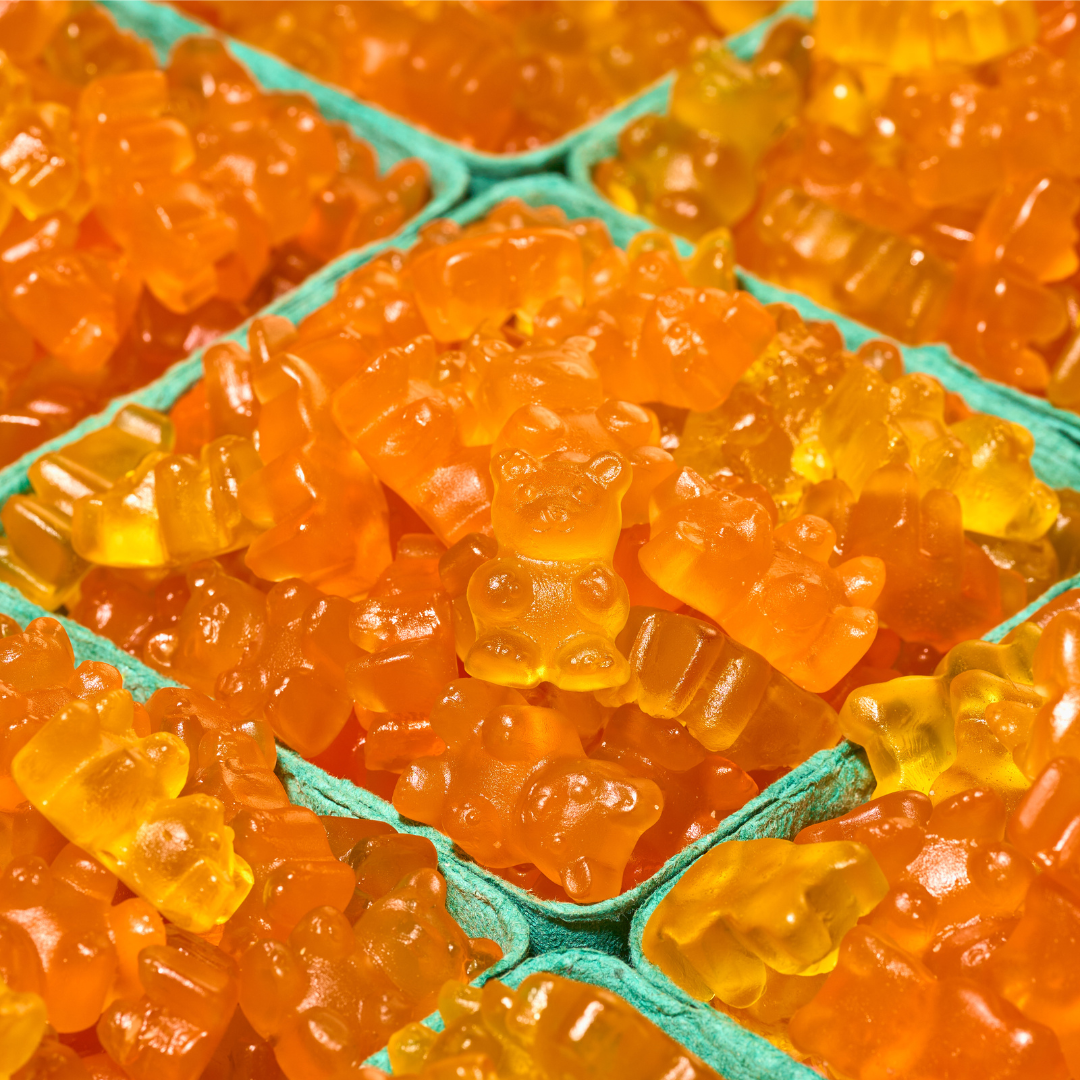 Close-up of orange gummy bears in a green container