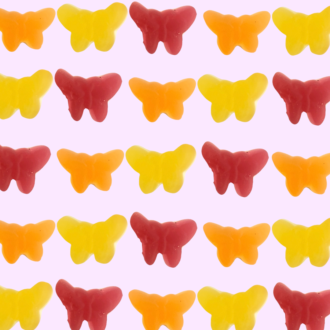 butterfly shaped gummies from Sweden over a pink background 