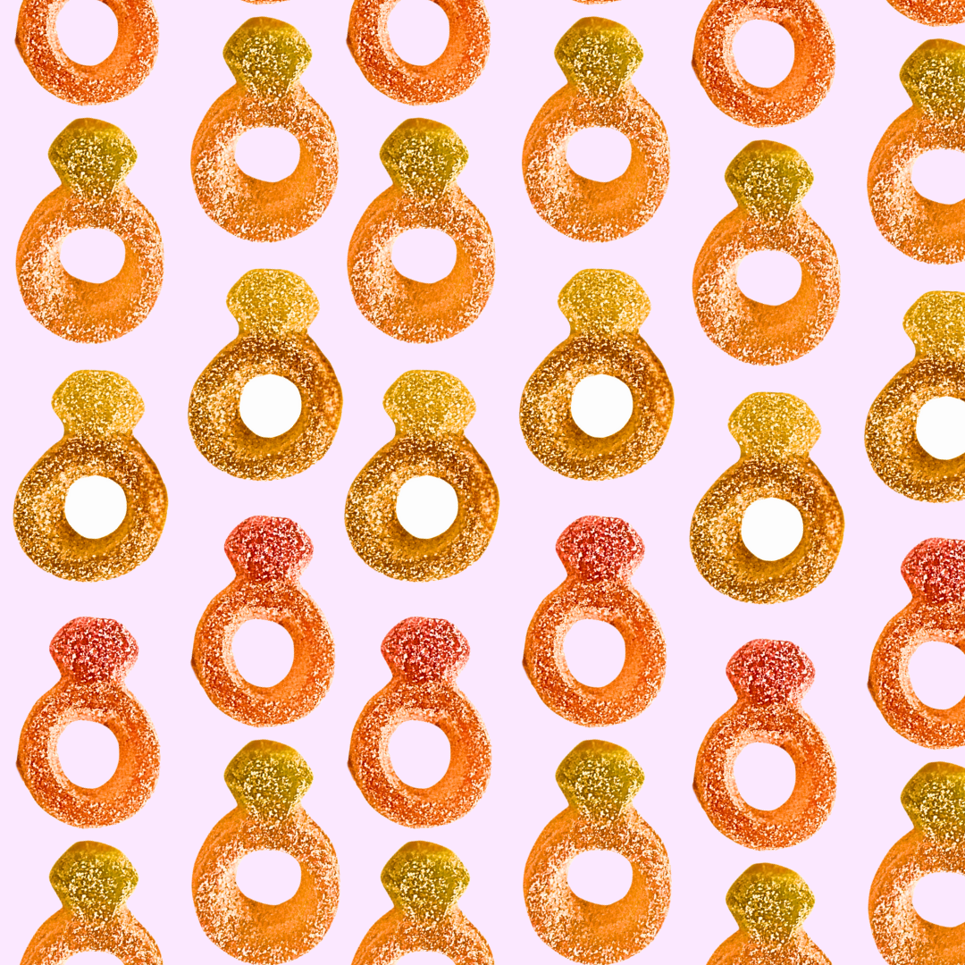 Pattern of colorful jelly candy rings on a pink background