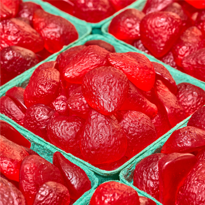 Close-up of red gummy strawberries in a green tray