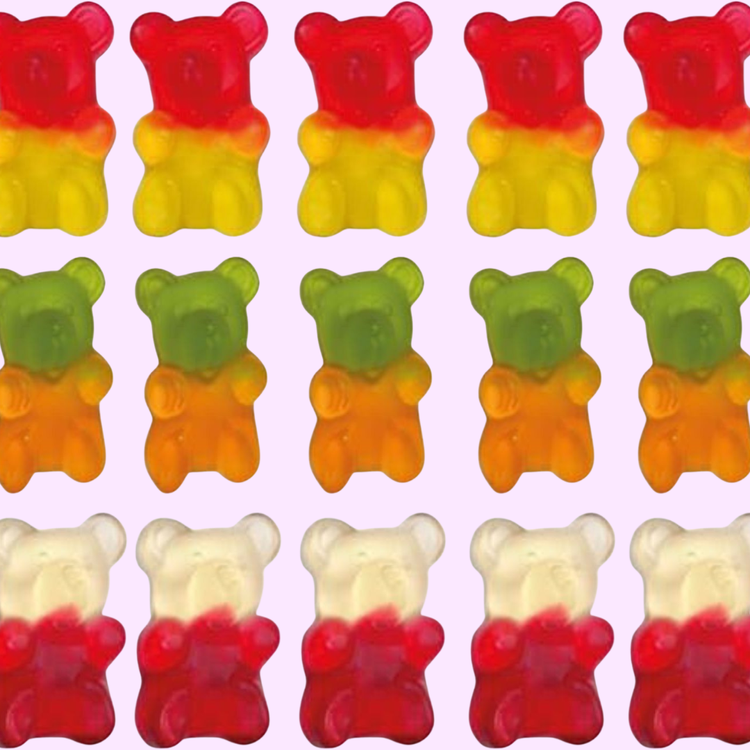 giant bear gummies in multiple colors over a light pink background