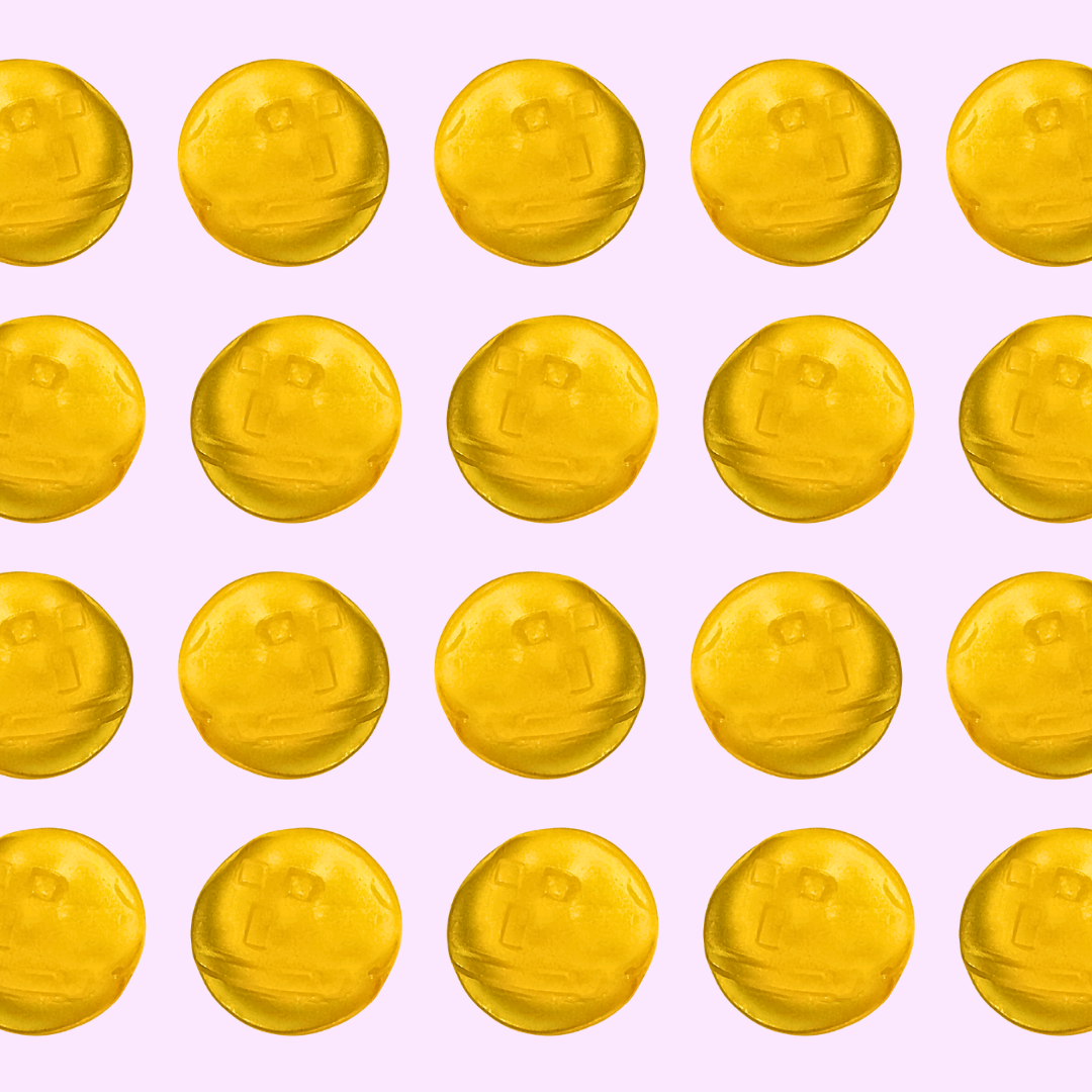 Pattern of yellow tropical flavored gummies on a pink background