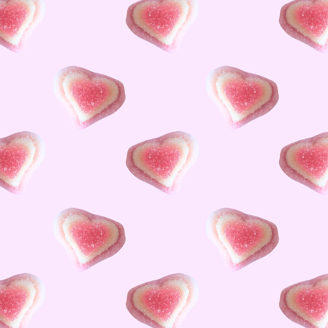 Heart-shaped gummy candies on a pink background