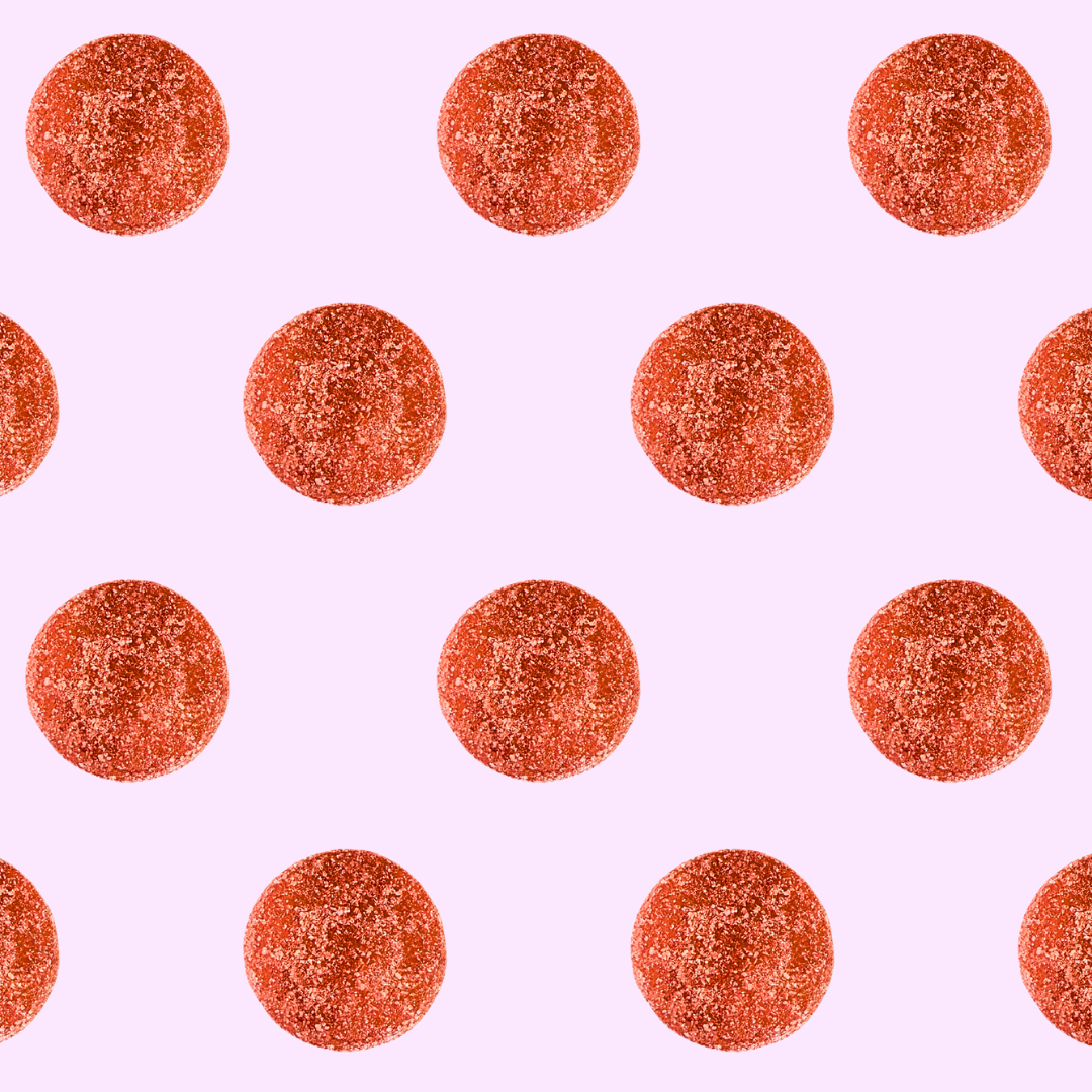 Pattern of red watermelon gummies on a pink background