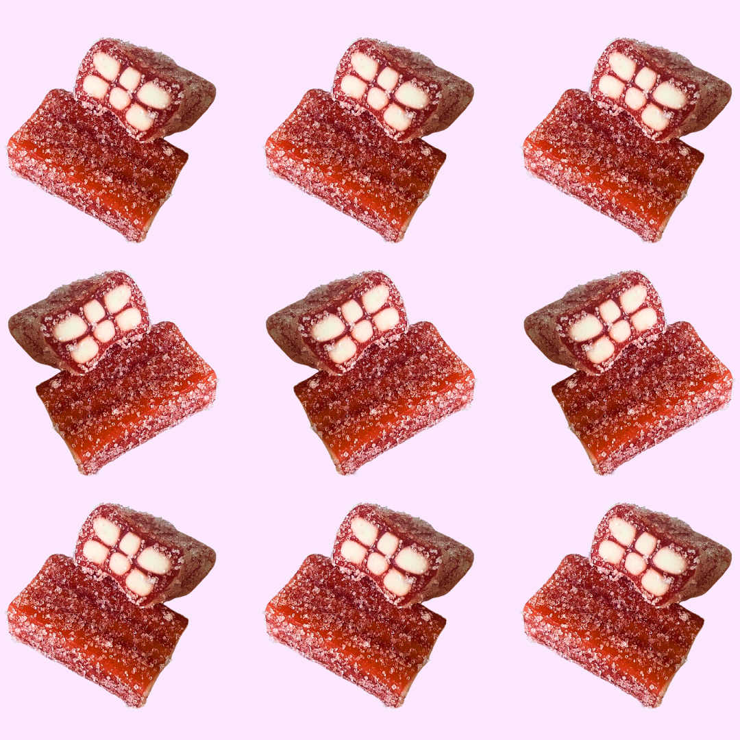 Red and white strawberry gummy candies on a light pink background