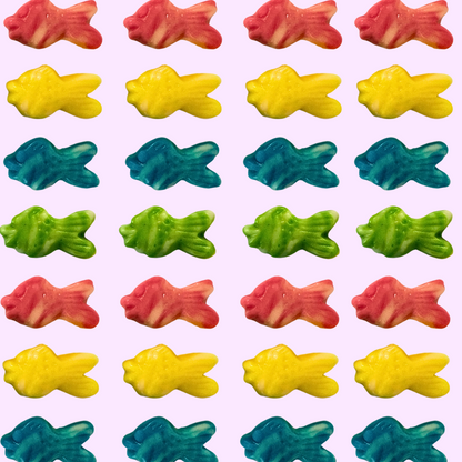 Pattern of colorful fish-shaped gummy candies on a pink background