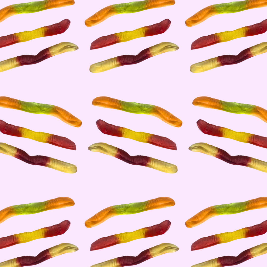 Pattern of colorful gummy worms on a pink background
