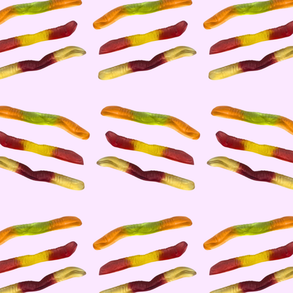 Pattern of colorful gummy worms on a pink background